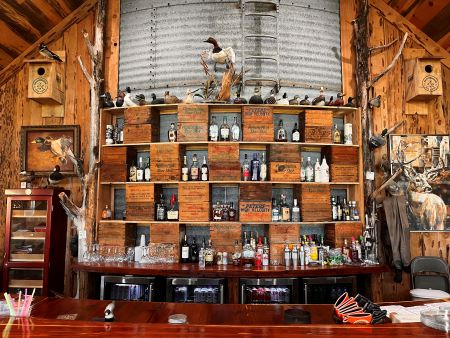 The bar in the Broomsedge Rod & Gun Club features old shotgun shell boxes. The original silo on the site is visible. There are three silos that were integrated into the lodge’s construction.