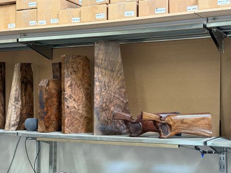 A Scientific Quest for Zero Recoil Leads a Physicist to Silicon Valley’s Grip+ 6 Fine wood blanks at the Grip+ facility in Hayward, California, waiting to become custom shotgun stocks. The two finished stocks shown at the right illustrate the transformation from raw wood selection to personalized stock geometry, where appearance, fit, grip shape, comb position, and recoil-management design all come together in the final build.
